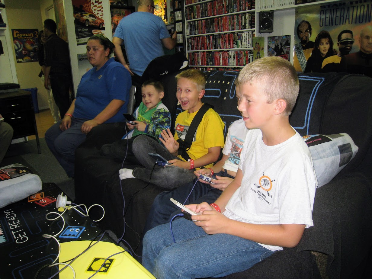 Children playing video games together on a couch during one of Syd Bolton's Game Nights